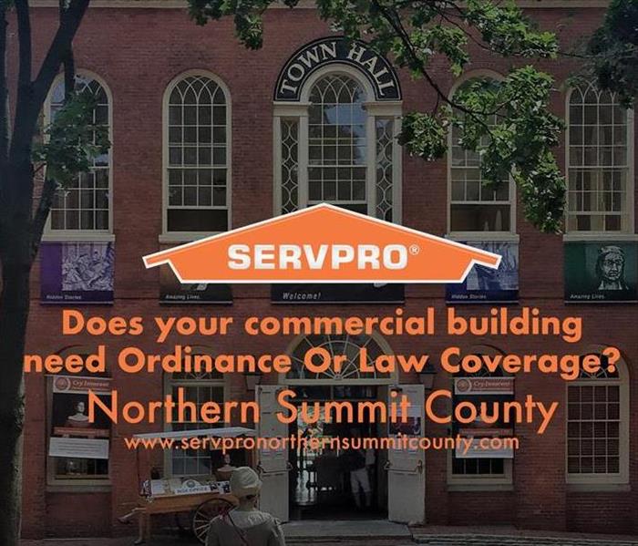 Orange SERVPRO logo with a commercial building faded in the background